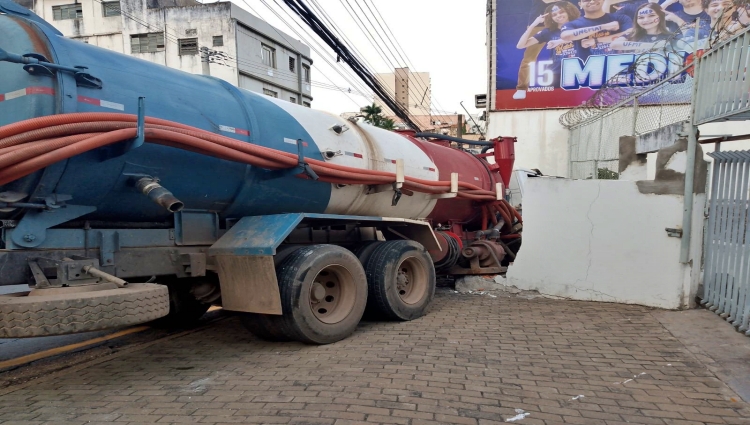 Motorista perde controle de caminhão limpa fossa e colide contra muro