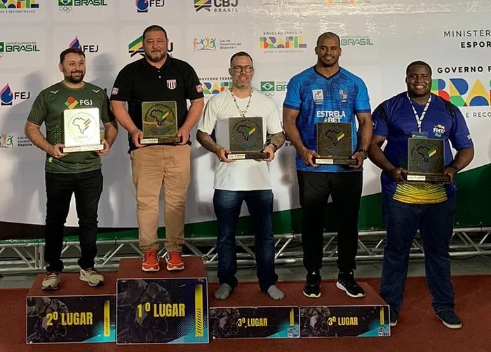 Treinador Vinicius Vilela à esquerda com o troféu da classificação geral