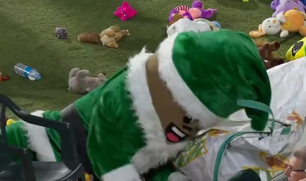 Mascote do Betis brinca com bichos de pelúcia arremessados pela torcida