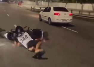 Motociclista empina moto, perde controle e bate o rosto no asfalto; veja vídeo